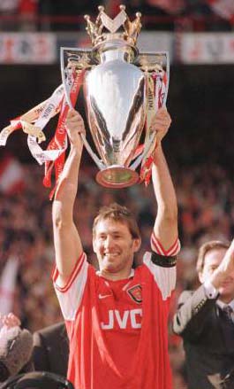 A jubilant Tony Adams holds up the cup